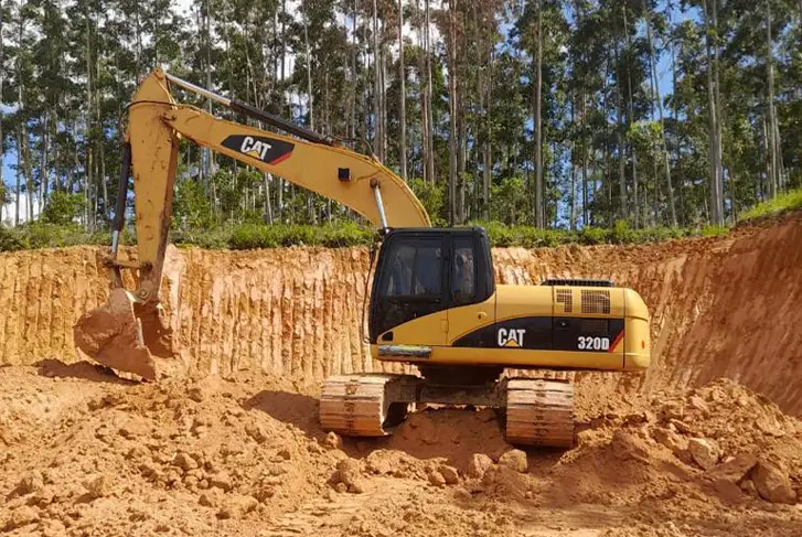 Escavadeira amarela cavando na terra